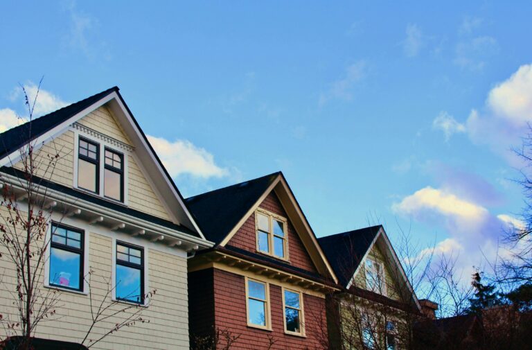 A row of houses along a Vancouver street under a blue sky