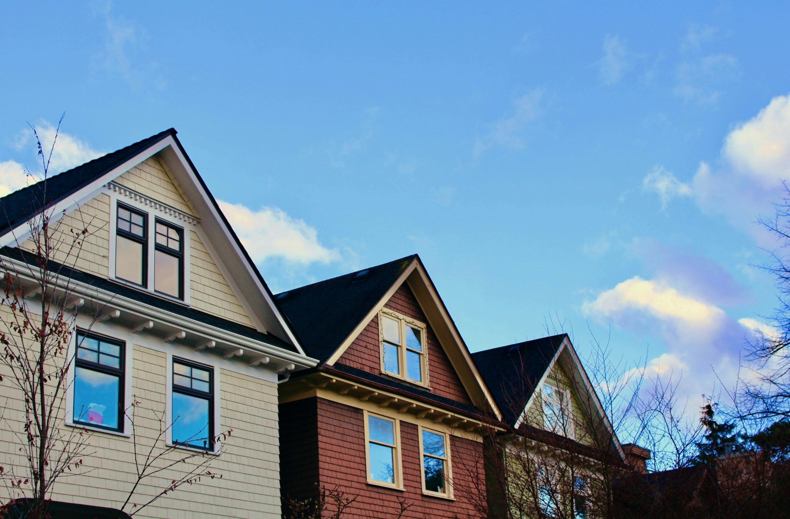 A row of houses along a Vancouver street under a blue sky